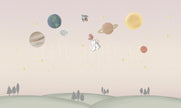 Ceylan Astronot Duvar Kağıdı; pembe-bej gökte gezegenler, roket ve astronot ceylan, altta yeşil tepeler | Craft Paper Co