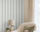 Striped Wallpaper Mural in Gnome Green; close-up of green stripes behind a cream armchair and lamp | Craft Paper Co