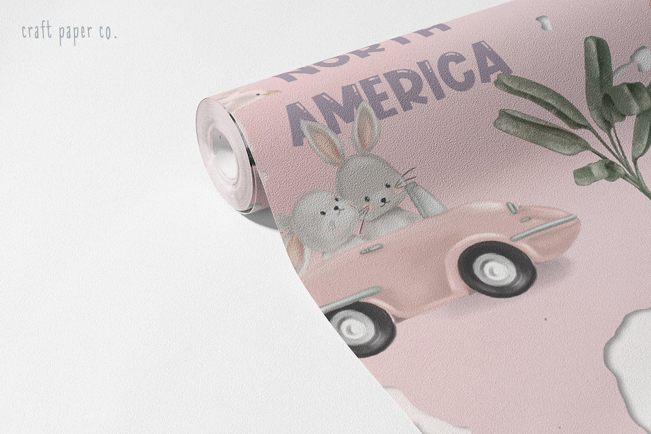 Pink World Map Wallpaper Mural; unrolled roll showing North America, a car with a bunny and a palm tree motif | Craft Paper Co