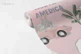 Pink World Map Wallpaper Mural; unrolled roll showing North America, a car with a bunny and a palm tree motif | Craft Paper Co