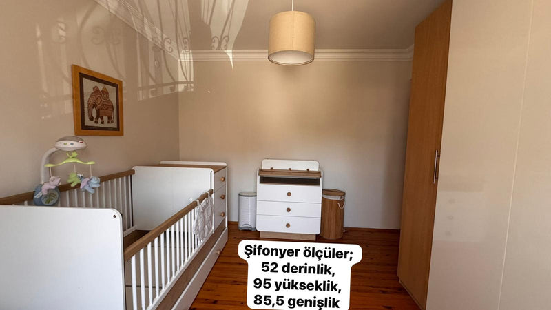 Bebek odasının şifonyer duvarı, boş hâli; karyola, şifonyer ve dolap yerinde, şifonyerin derinlik, yükseklik ve genişlik ölçüleri fotoğrafa yazılmış