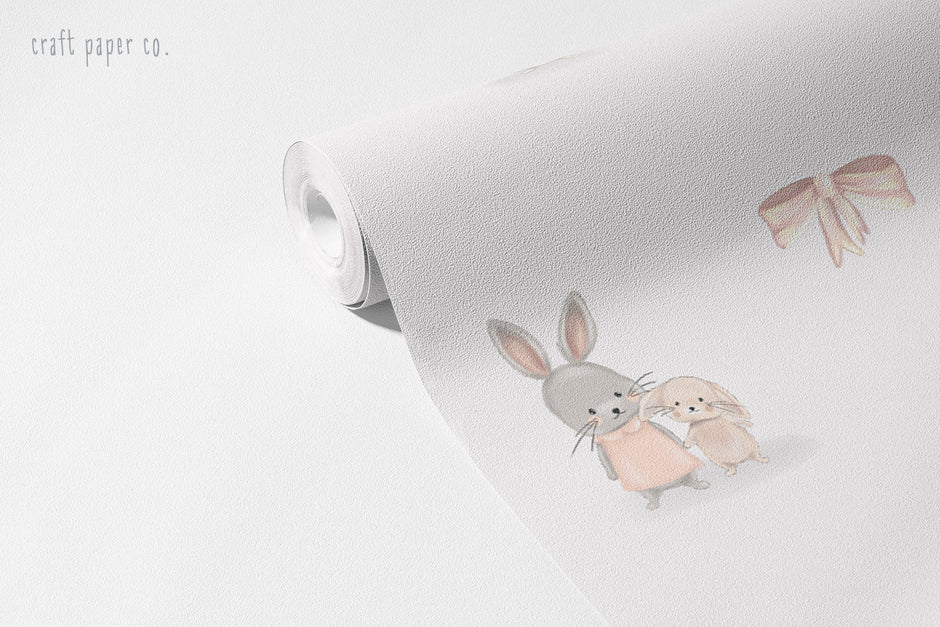 Mini Tavşanlı Desen Duvar Kağıdı; açılmış rulo üzerinde tavşan ikilisi ve pembe kurdele | Craft Paper Co