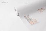 Mini Tavşanlı Desen Duvar Kağıdı; açılmış rulo üzerinde tavşan ikilisi ve pembe kurdele | Craft Paper Co