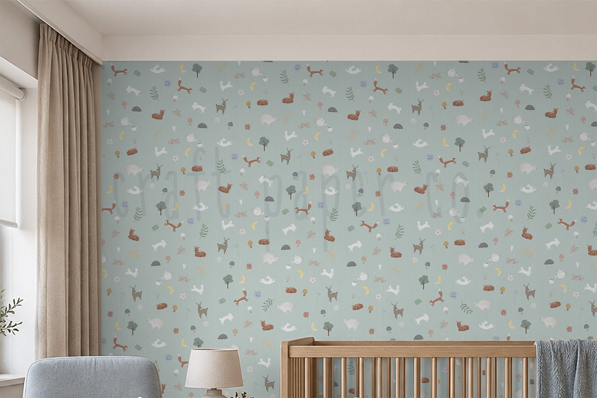 Nordik Desen Duvar Kağıdı yakın çekim; pastel mint zeminde minik orman hayvanları, gri koltuk ve kapalı masa lambası | Craft Paper Co