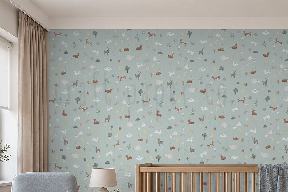 Nordik Desen Duvar Kağıdı yakın çekim; pastel mint zeminde minik orman hayvanları, gri koltuk ve kapalı masa lambası | Craft Paper Co