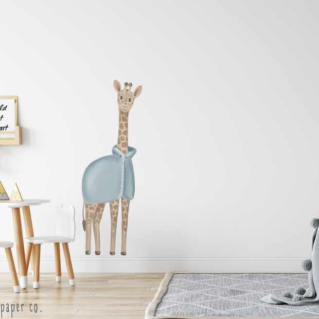 Yağmurluk Giyen Zürafa Çocuk Odası Duvar Sticker; çocuk masası ve gri halının olduğu odada duvarda mavi yağmurluklu zürafa | Craft Paper Co